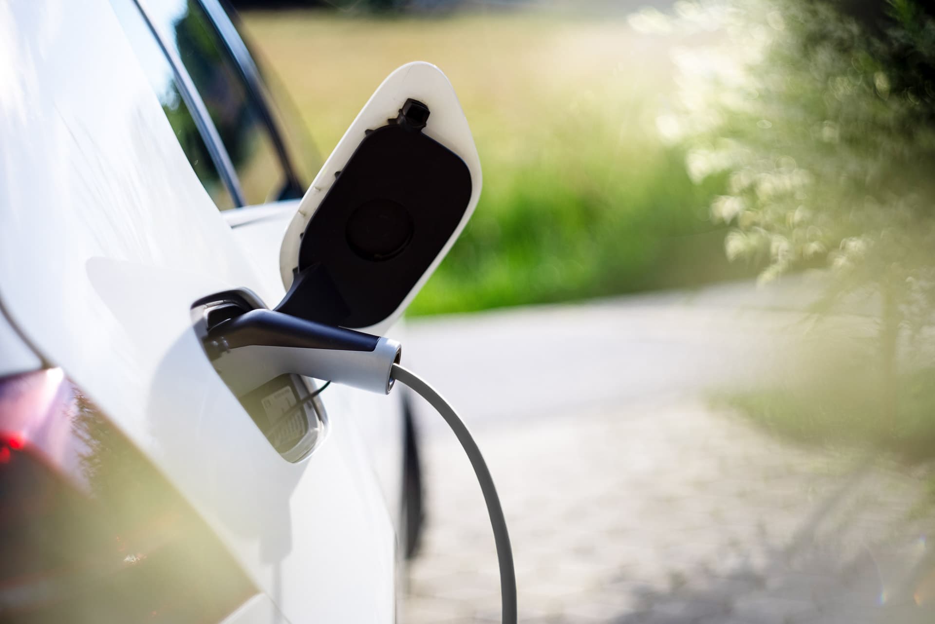 Kvinde ser på sin APP mens hun lader elbilen