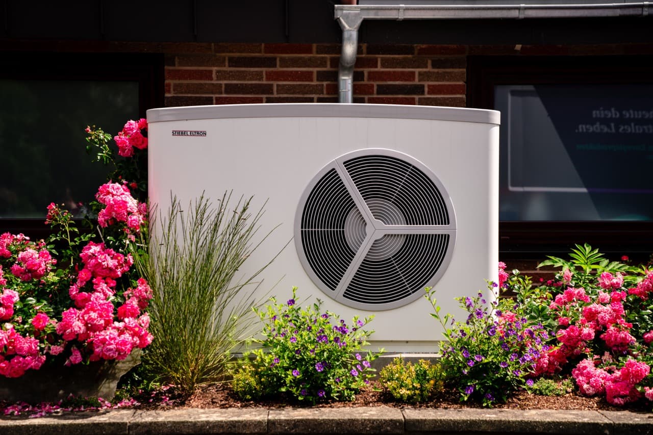 Varmepumpe med blomster omkring
