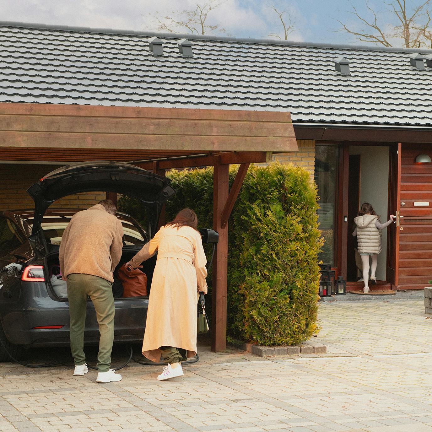 Familie med elbil udenfor deres husstand
